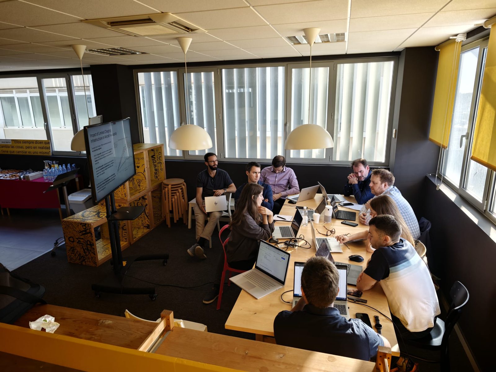 Socios del consorcio VERTI-GO trabajando con sus portátiles alrededor de una mesa durante la segunda jornada en Málaga